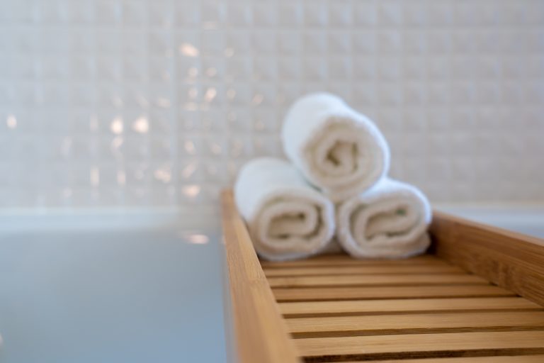 Spa bath with towels on wooden shelf